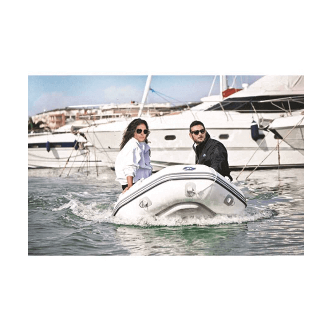 Tender compatto Eurovinil bianco con chiglia gonfiabile in uso in marina con due persone a bordo