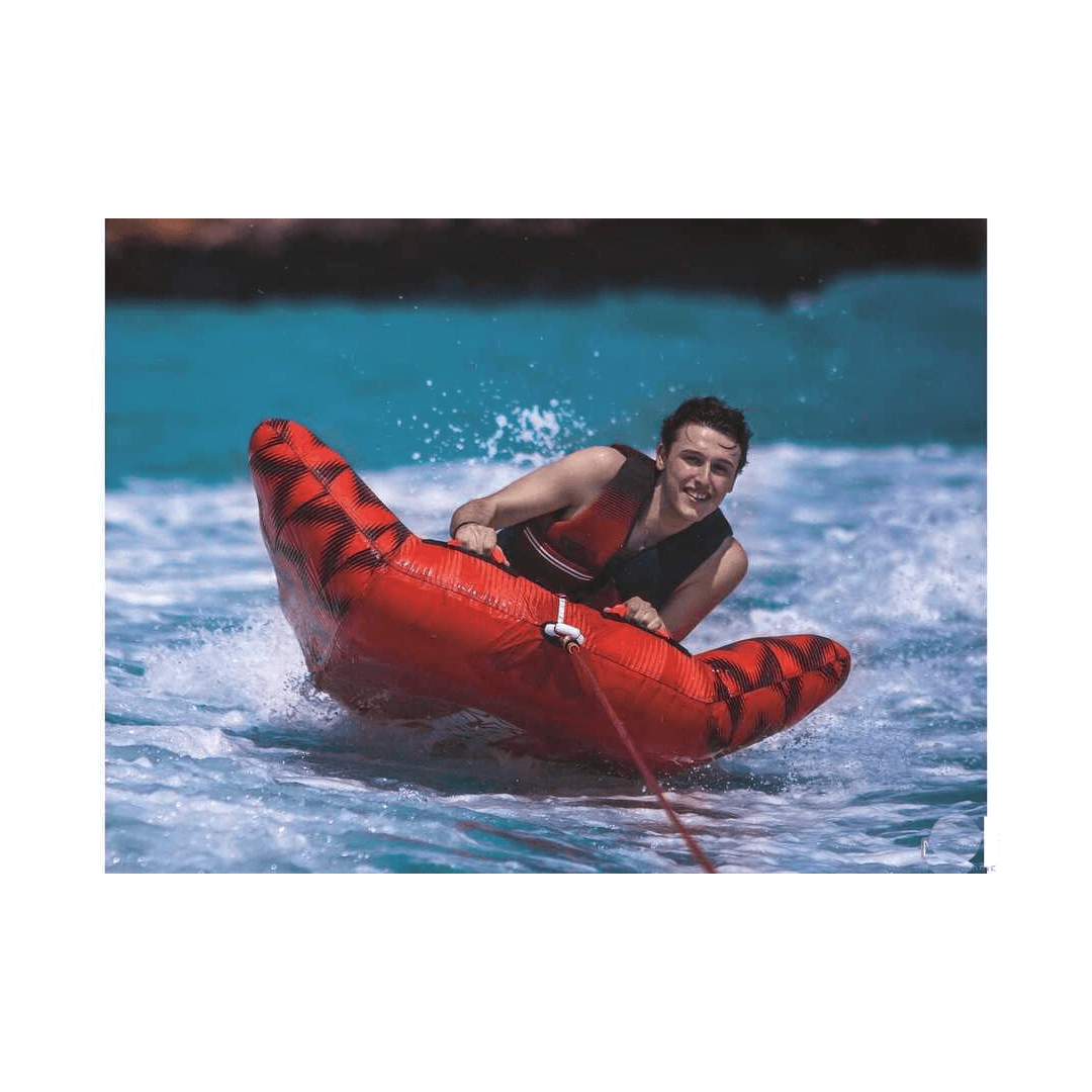 Ragazzo sorride su Ski Tube JOBE HYDRA rosso con motivo nero trainato in acqua