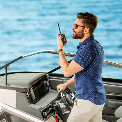 Diportista che chiama al VHF portatile Cobra BlueBound 150E nero alla console di guida